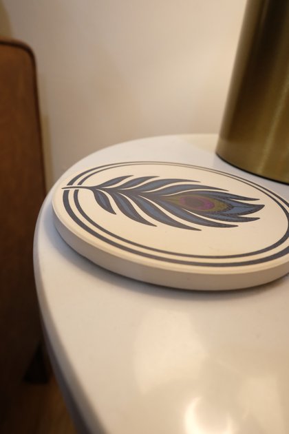 A small feather-mark coaster resting on a side table