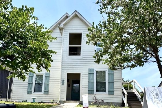 The office at 822 Meridian Street, Nashville — a white house with a teal front door, framed by trees