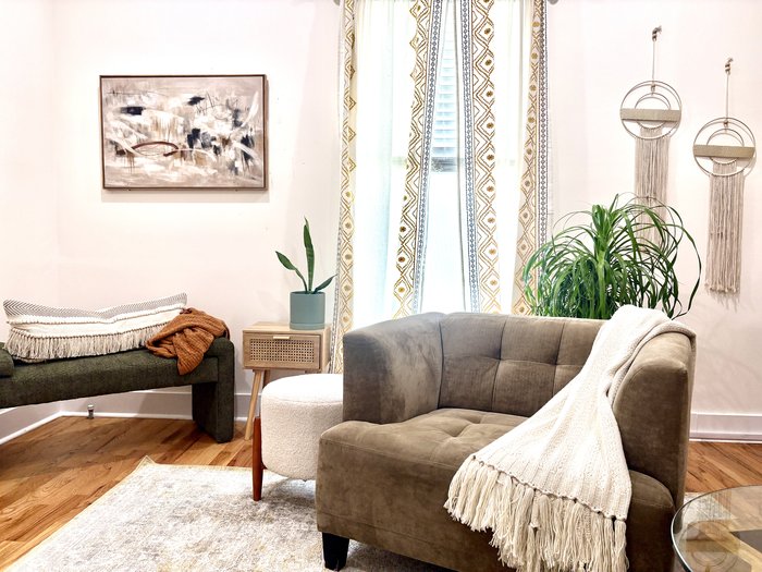 The therapy room at Whole Self Counseling — a bench, armchair, and soft window light.